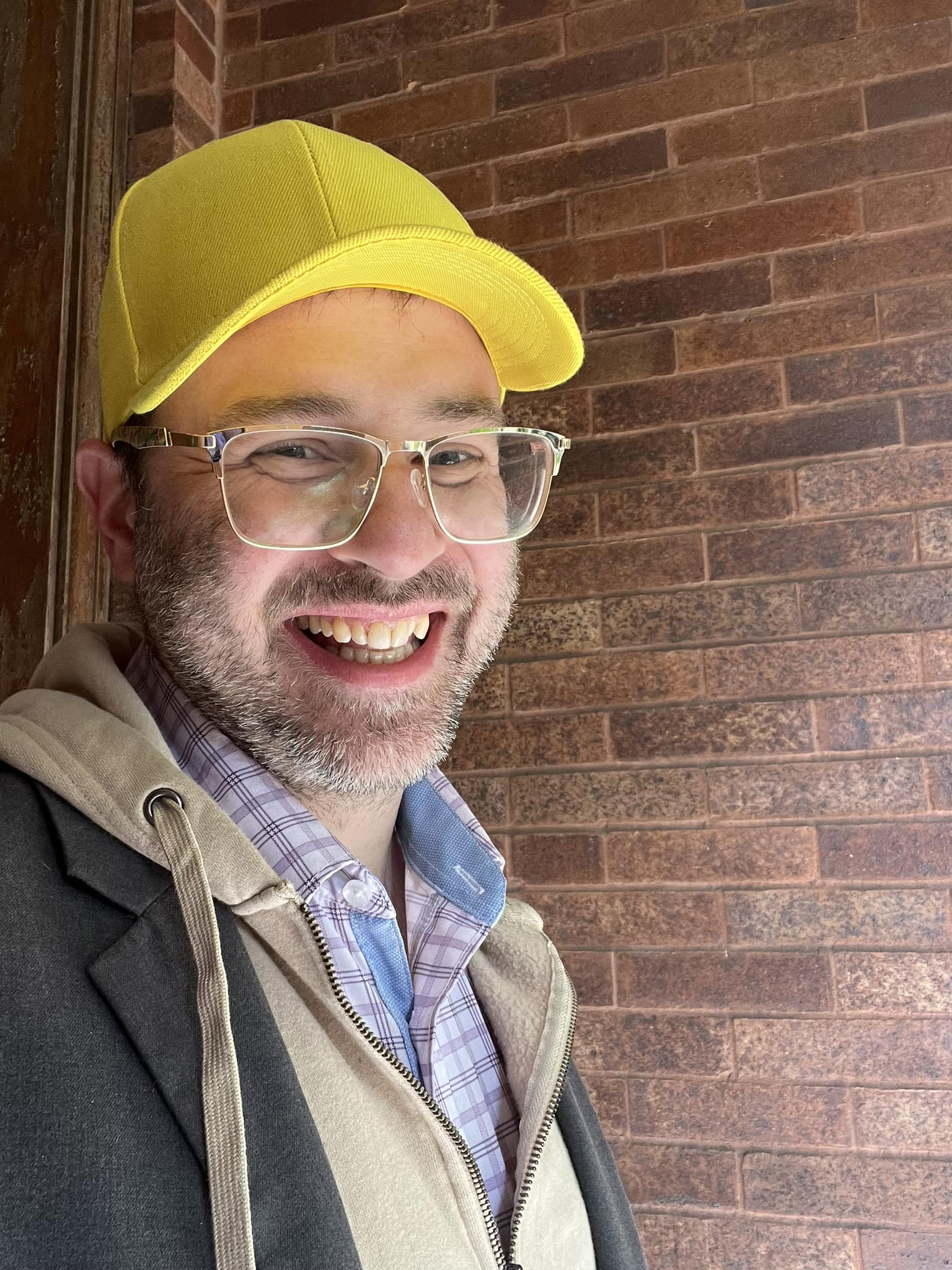 Daniel Kleinman smiling in a yellow cap